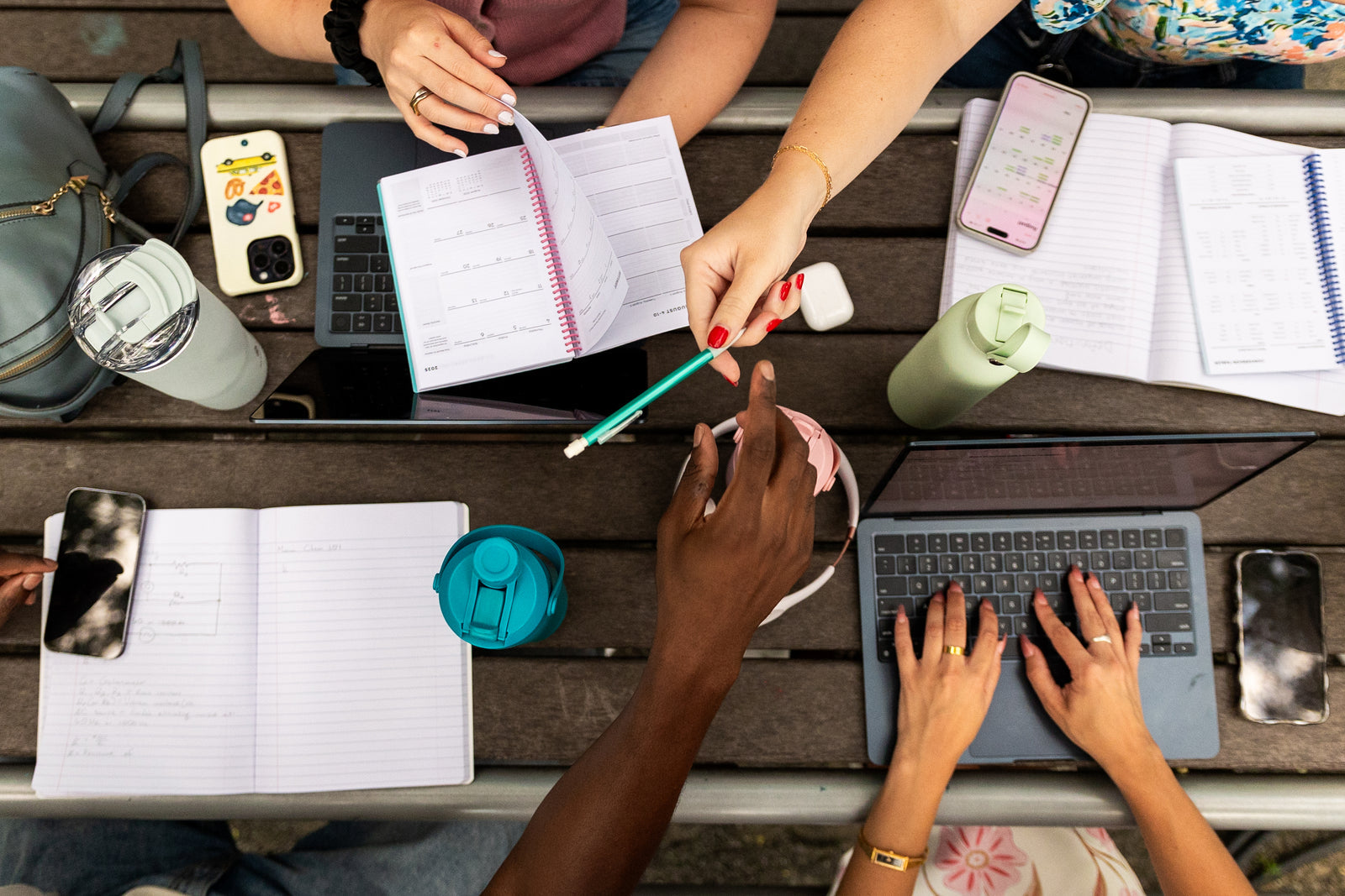 Manna bottles and tumblers alongside notebooks and laptops